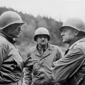 Brigadegeneraal Milton B. Halsey, bevelvoerend generaal van de 97ste Infanteriedivisie van het Amerikaanse 3de Leger, spreekt met andere officieren tijdens een inspectietocht door concentratiekamp Flossenbürg nabij Weiden, Duitsland, waar honderden dwangarbeiders werden vermoord door fenolinjecties, machinegeweervuur of ophanging, waarna ze werden gecremeerd.