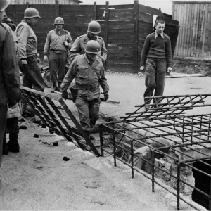 Brigadegeneraal Milton B. Halsey, bevelvoerend generaal van de 97ste Infanteriedivisie van het Amerikaanse 3de Leger, afkomstig uit Huntsville, Alabama, tijdens een inspectietocht door concentratiekamp Flossenbürg nabij Weiden, Duitsland, waar honderden dwangarbeiders werden vermoord door fenolinjecties, machinegeweervuur of ophanging, waarna ze werden gecremeerd in ovens.