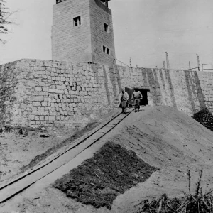 Tunneluitgang van concentratiekamp Flossenbürg nabij Weiden, Duitsland, waar honderden dwangarbeiders werden vermoord toen zij verzwakten door ondervoeding. Uit onderzoek bleek dat de nazi's slachtoffers vermoordden met fenolinjecties, machinegeweervuur of door ophanging. Zolang zij nog in leven waren, werden de dwangarbeiders gedwongen te werken in de nabijgelegen Messerschmitt-vliegtuigfabriek en de steengroeve. De 97ste Divisie van het Amerikaanse 3de Leger legde het kamp bloot.