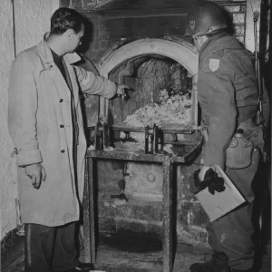 Een Franse gids toont een officier van de 97ste Divisie het crematorium waar de lichamen van Joodse, Franse, Russische en Slavische dwangarbeiders die stierven in concentratiekamp Flossenbürg, Duitsland, werden gecremeerd. Het kamp werd ontdekt door de 97ste Infanteriedivisie van het Amerikaanse 3de Leger.